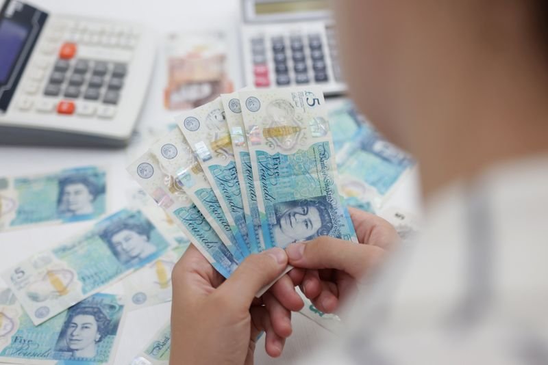 © Reuters. FILE PHOTO: Woman holds British Pound banknotes in this illustration taken May 30, 2022. REUTERS/Dado Ruvic/Illustration/File photo